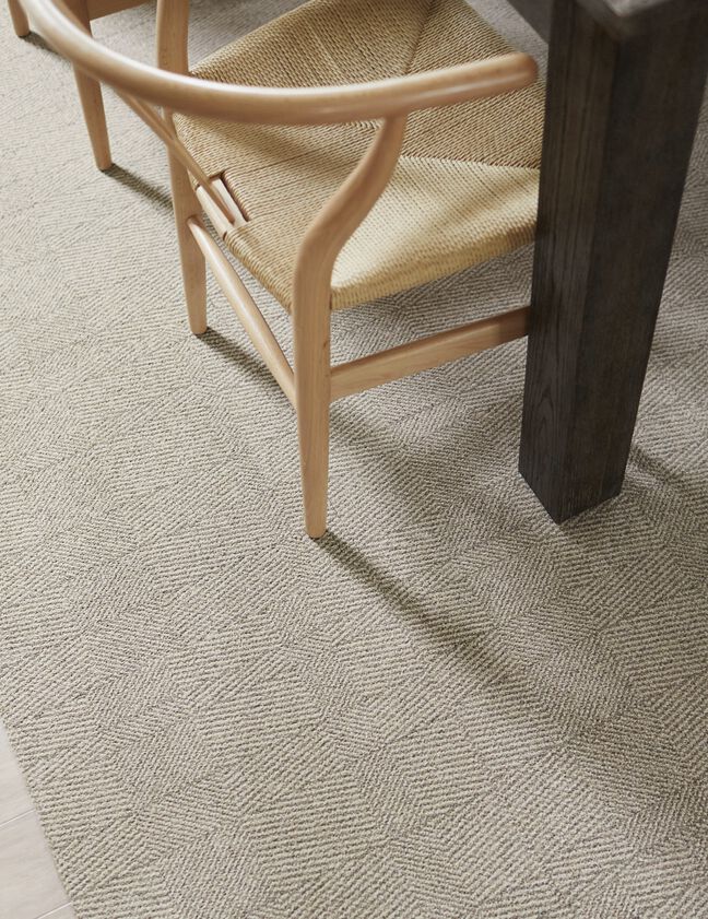 Detail of dining room with FLOR Tweed Indeed area rug shown in Dune